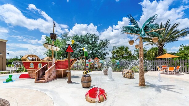 A water play area with a pirate ship, palm trees, and a fountain.