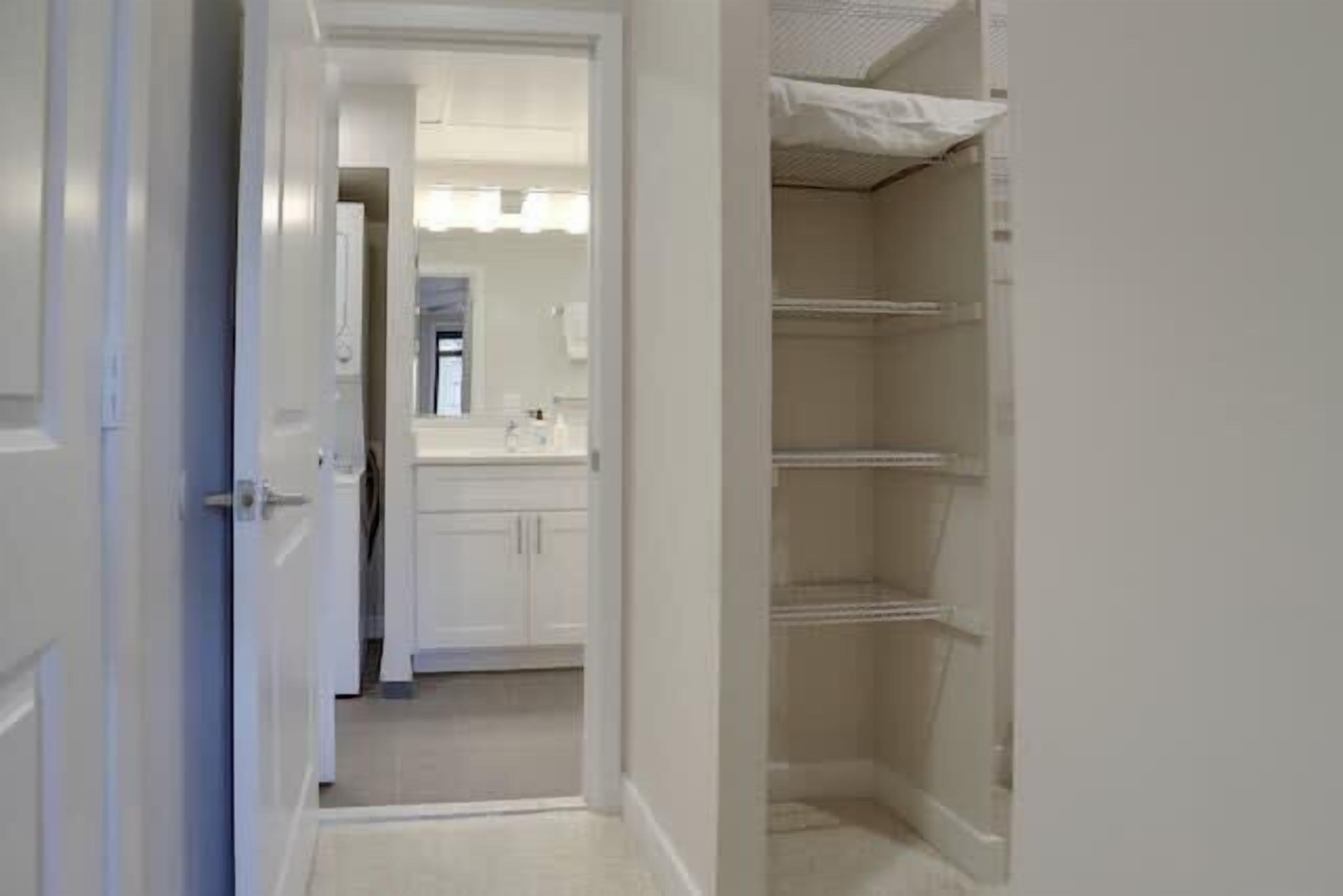 Um corredor com banheiro e closet espaçoso.