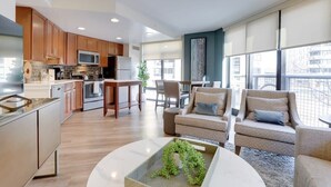A modern kitchen with wooden cabinets, stainless steel appliances, and a dining area with a table and chairs.