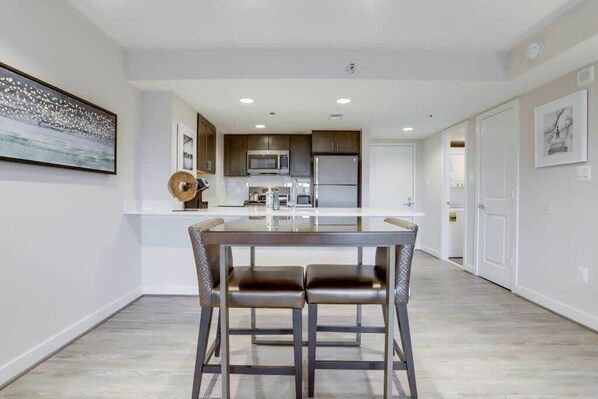 Una cocina moderna con electrodomésticos de acero inoxidable, una isla central con asientos y un diseño minimalista.