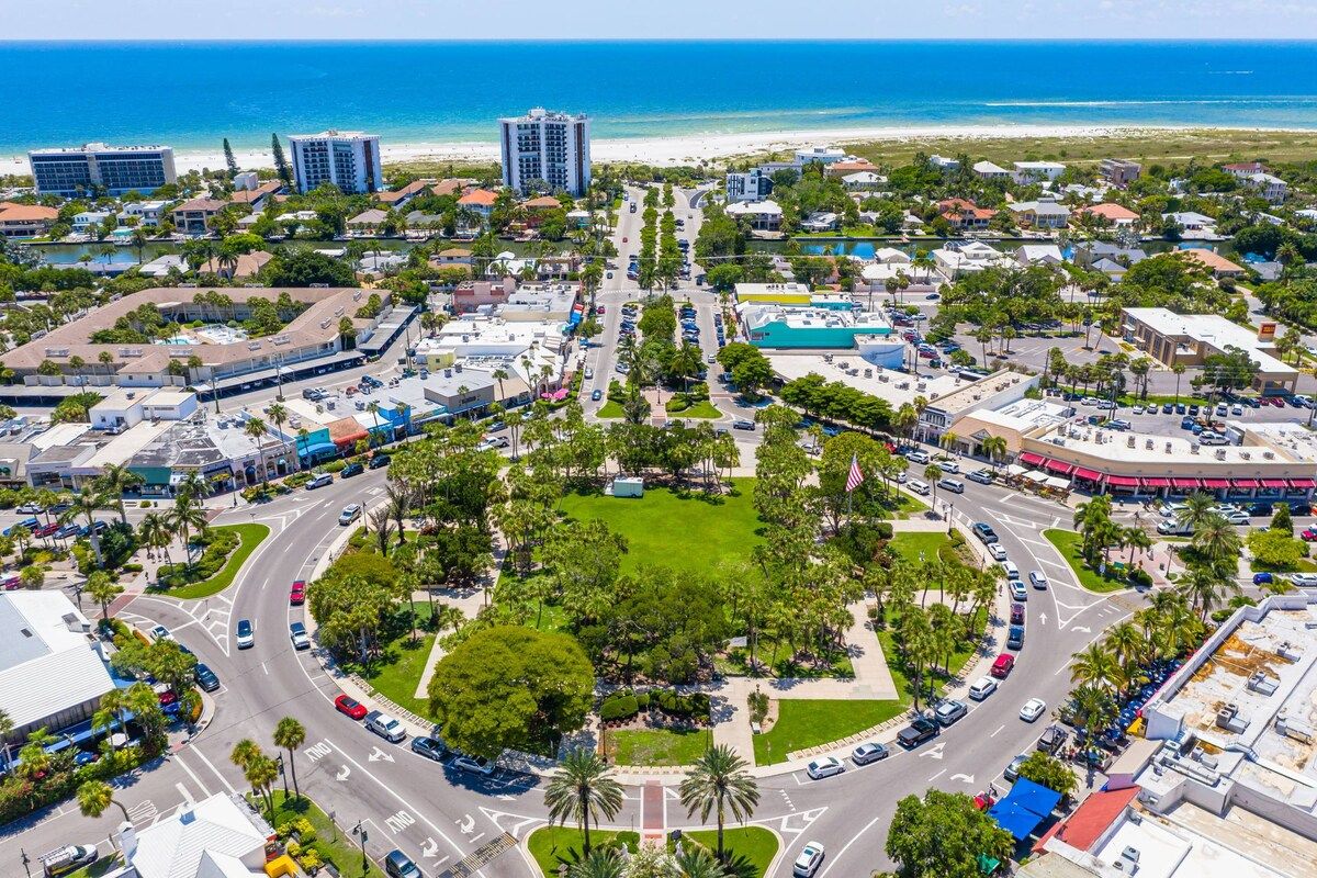 A coastal cityscape with a central roundabout, beachfront hotels, and a mix of residential and commercial buildings.