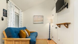 A cozy room with a blue sofa, wooden side table, and a floor lamp.