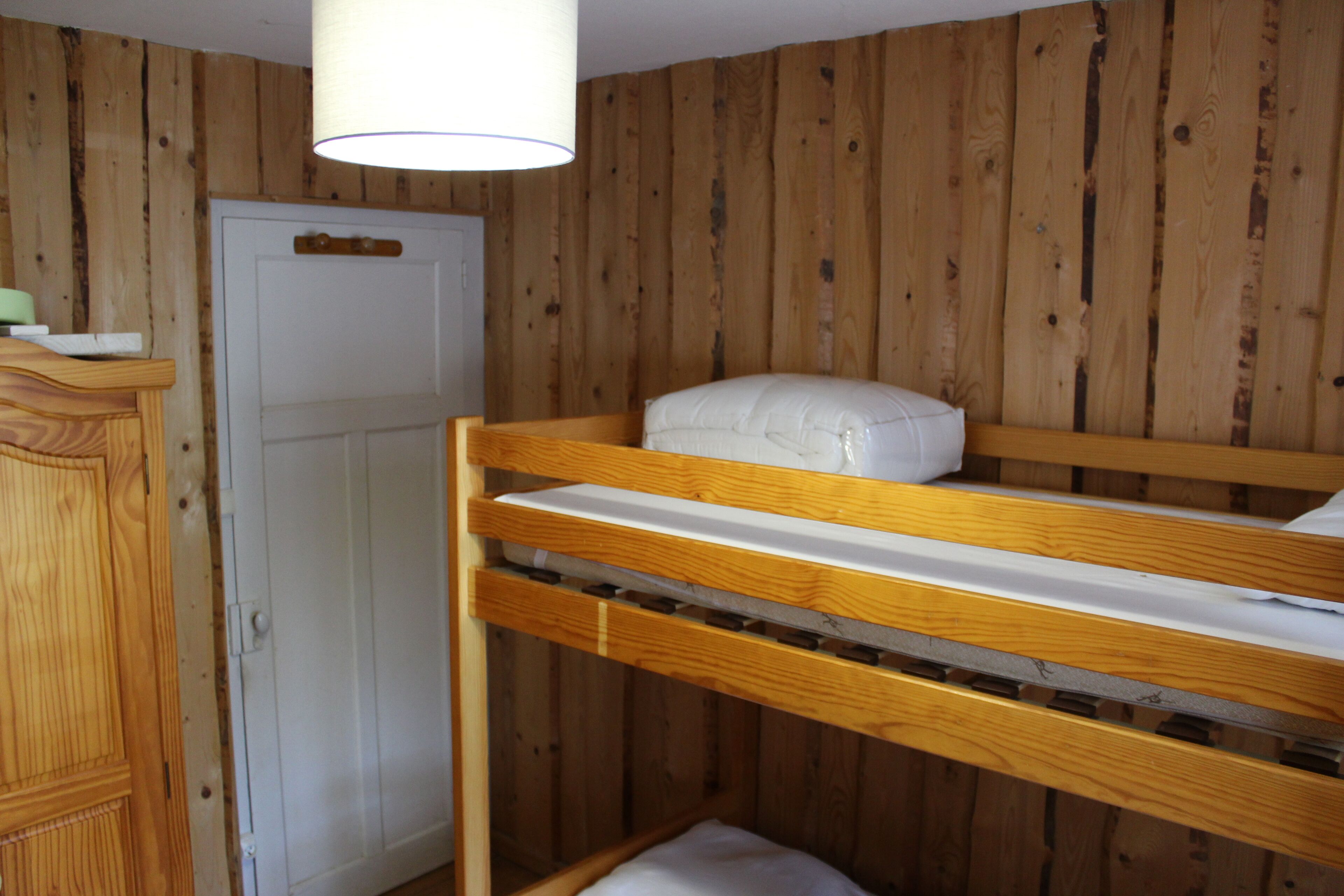 Un lit superposé avec un oreiller et une tête de lit en bois.
