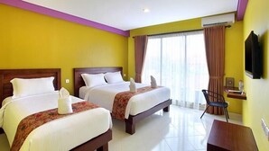 Habitación de hotel con dos camas, un escritorio, una silla y un televisor.