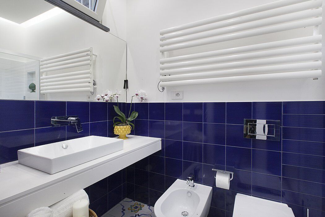 Un baño moderno con un lavamanos blanco, un bidé y un espejo.