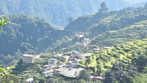 A mountainous village with terraced fields and buildings. - Hotel Anandam Phata (Ukhimath)