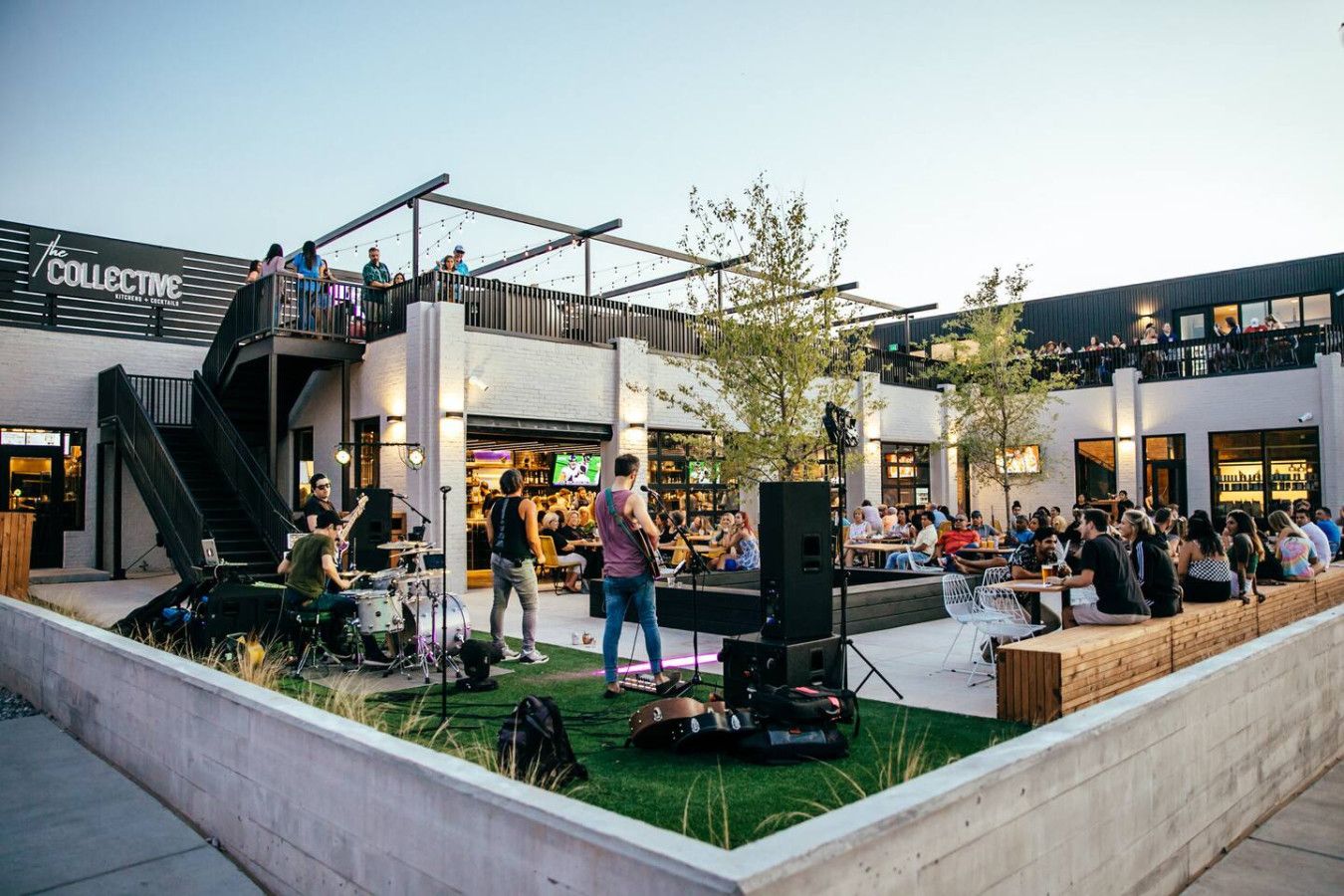 An outdoor event with a stage, seating, and a crowd.
