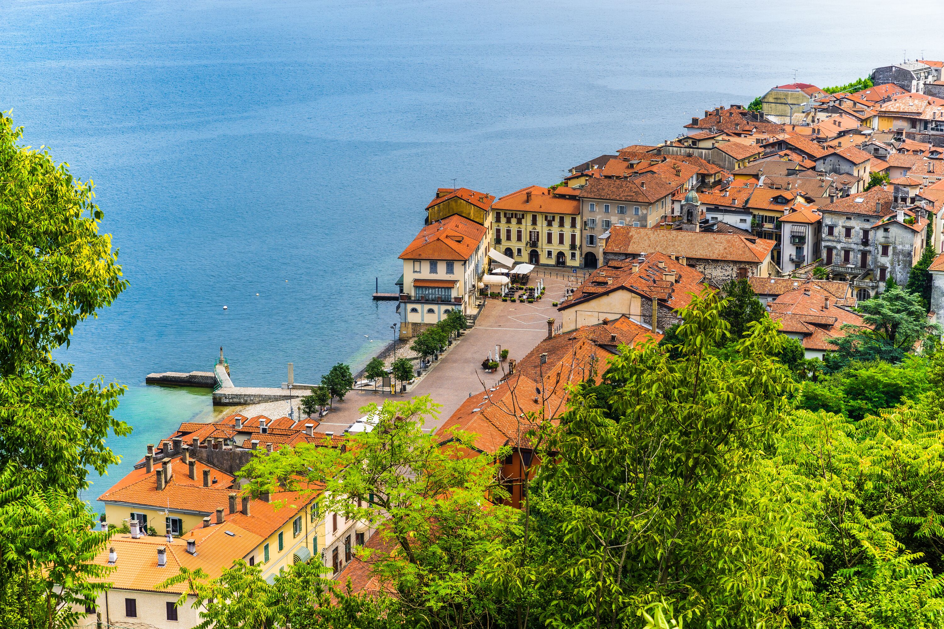 A coastal town with historic buildings, a waterfront promenade, and lush greenery.