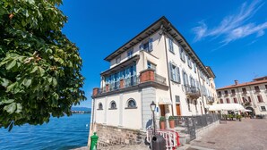 A waterfront building with a balcony, a stone wall, and a clear view of the water.