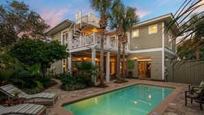 A two-story house with a pool, outdoor seating, and a covered patio. - Steps from Beach access, Private pool, Gorgeous décor -Big Palm Little Palm (Seacrest)