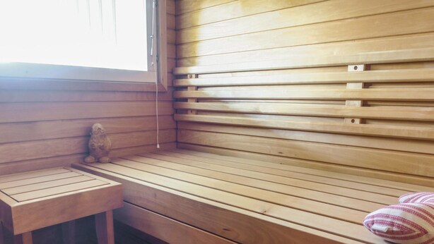 Un banco de sauna de madera con una mesita y un adorno decorativo.