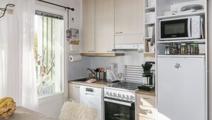 Cocina compacta con estufa, horno, microondas y refrigerador.