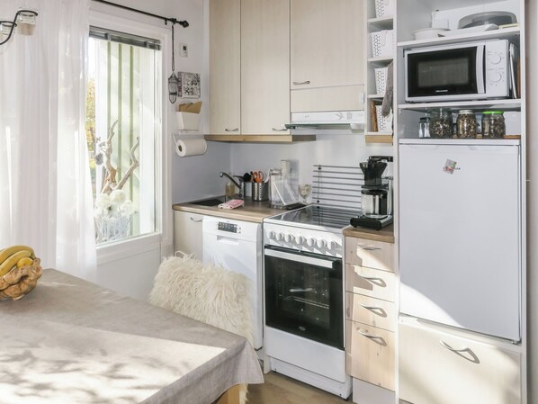 Cocina compacta equipada con estufa, horno, microondas y refrigerador.