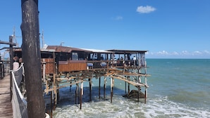 A wooden pier with a restaurant on stilts over the water, offering views of the sea. - La Vigna di Ranco Ltd N3352 (Paglieta)