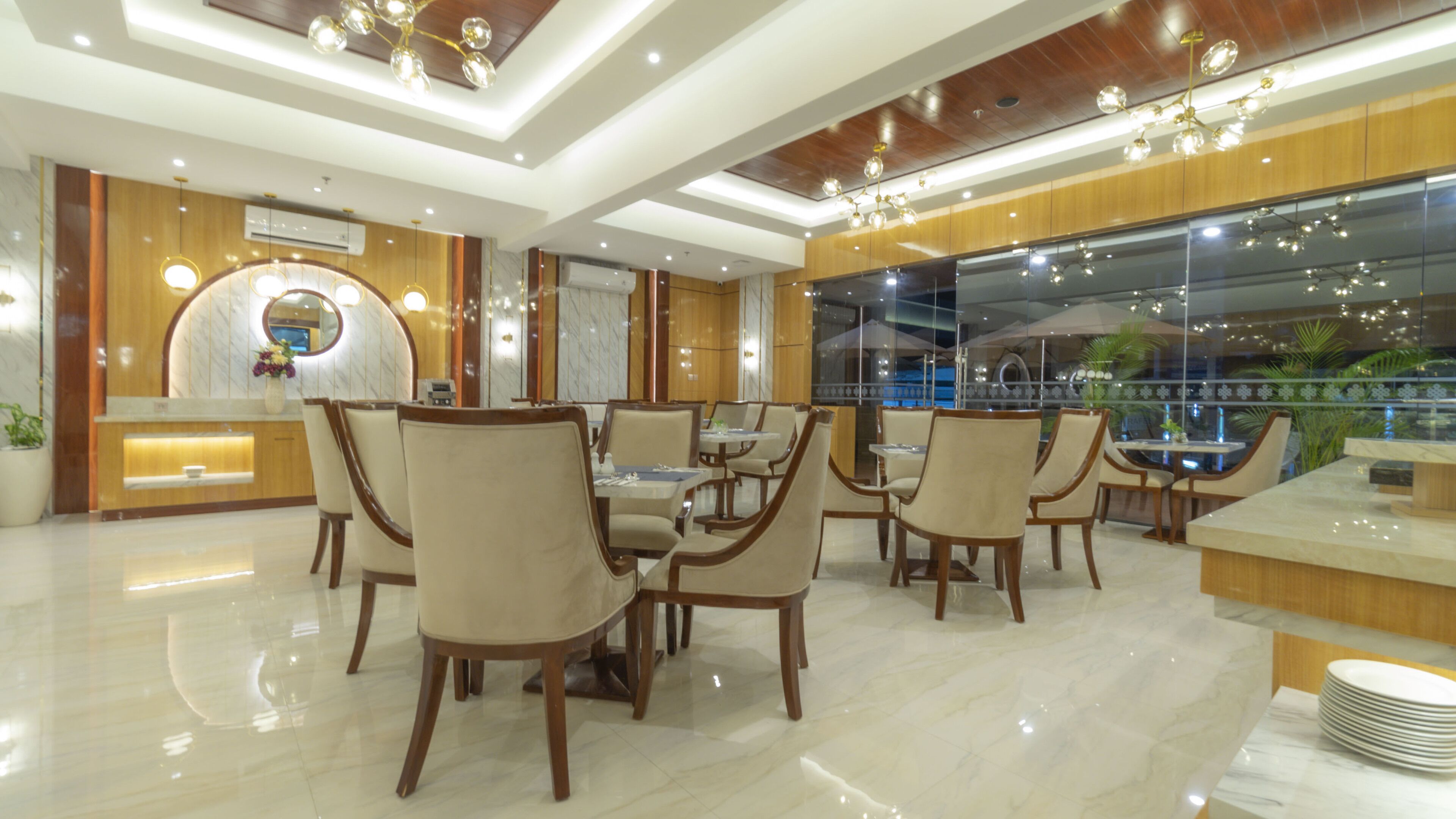 A modern dining area with wooden paneling, marble flooring, and a view of a pool through large windows.