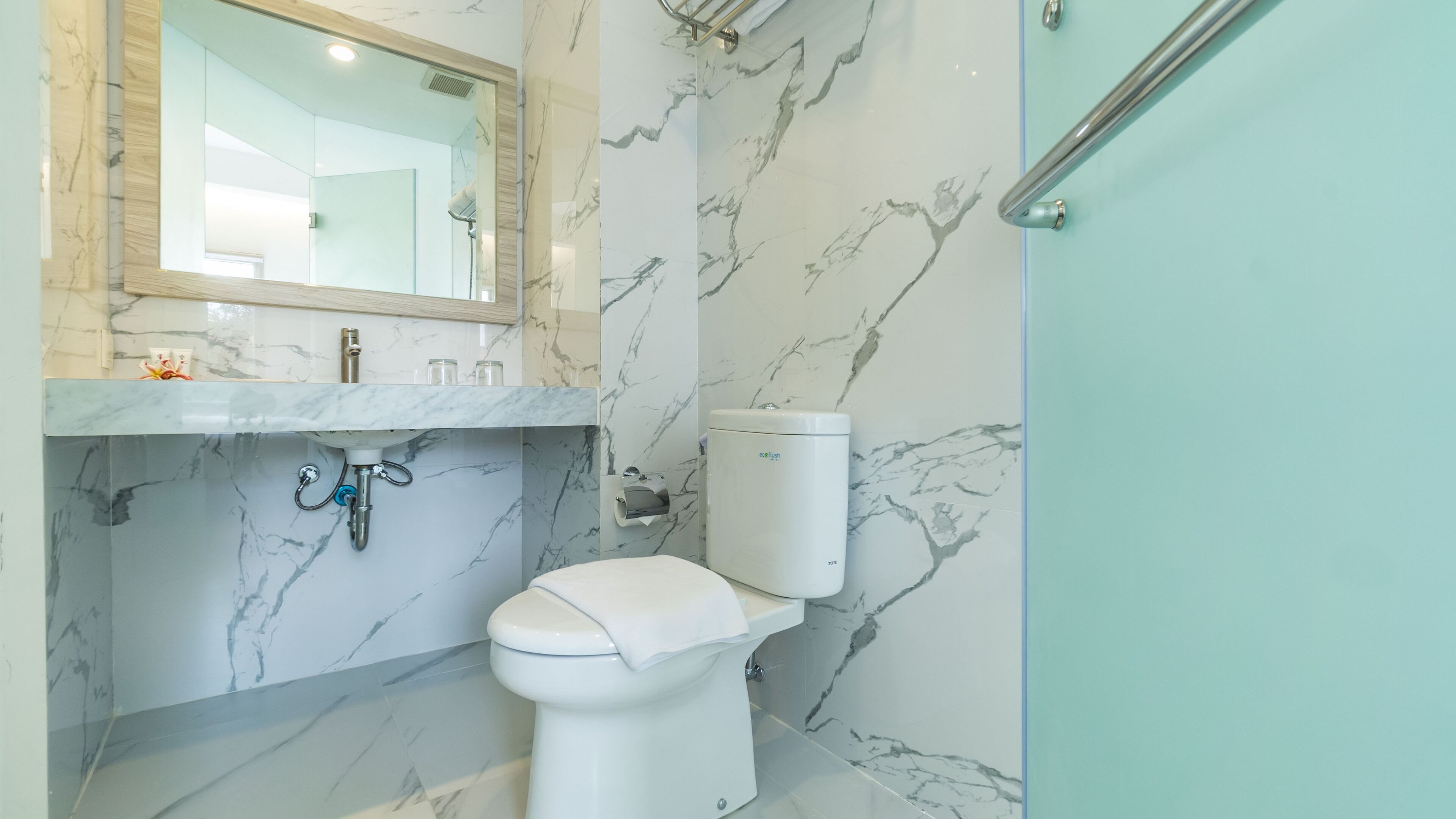A bathroom with a marble sink, toilet, and shower.