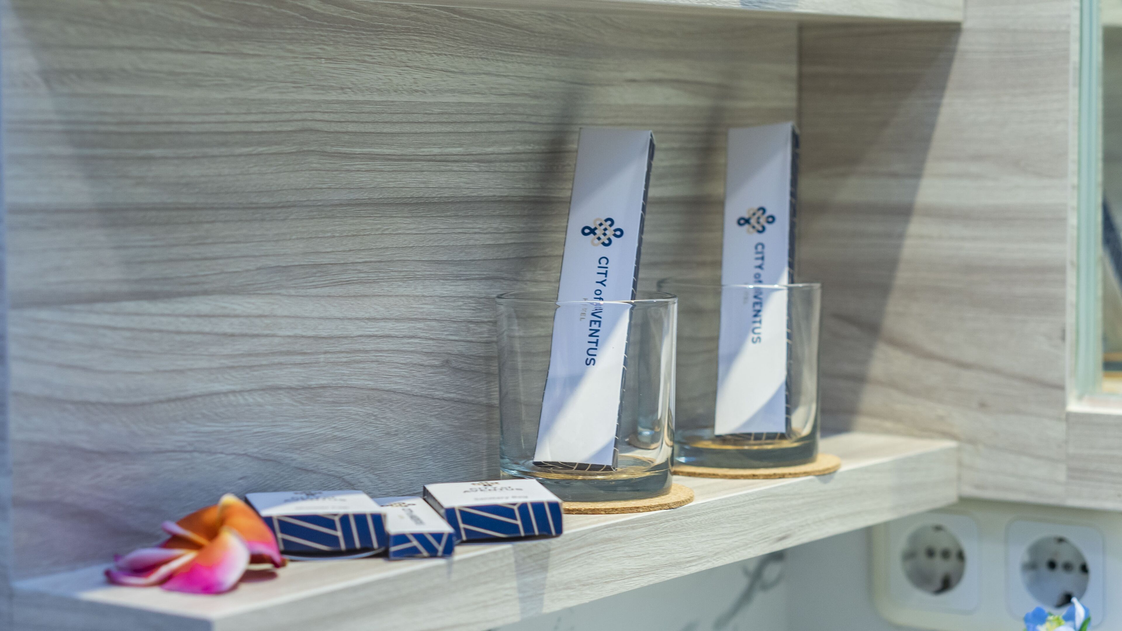 Een plank met twee glazen en twee dozen, waarvan er één het label 