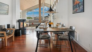 Um interior moderno com área de jantar, lareira e uma grande janela com vista.
