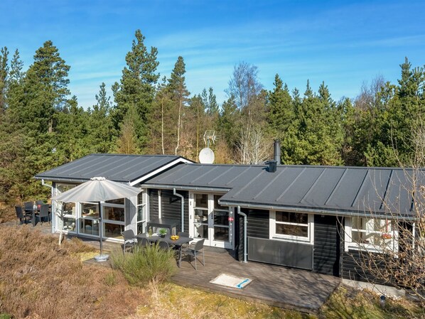 Een modern huis met een ruim terras, een overdekte patio en een garage.