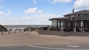 Un restaurant situé en bord de mer, avec une terrasse offrant une vue sur l’océan.