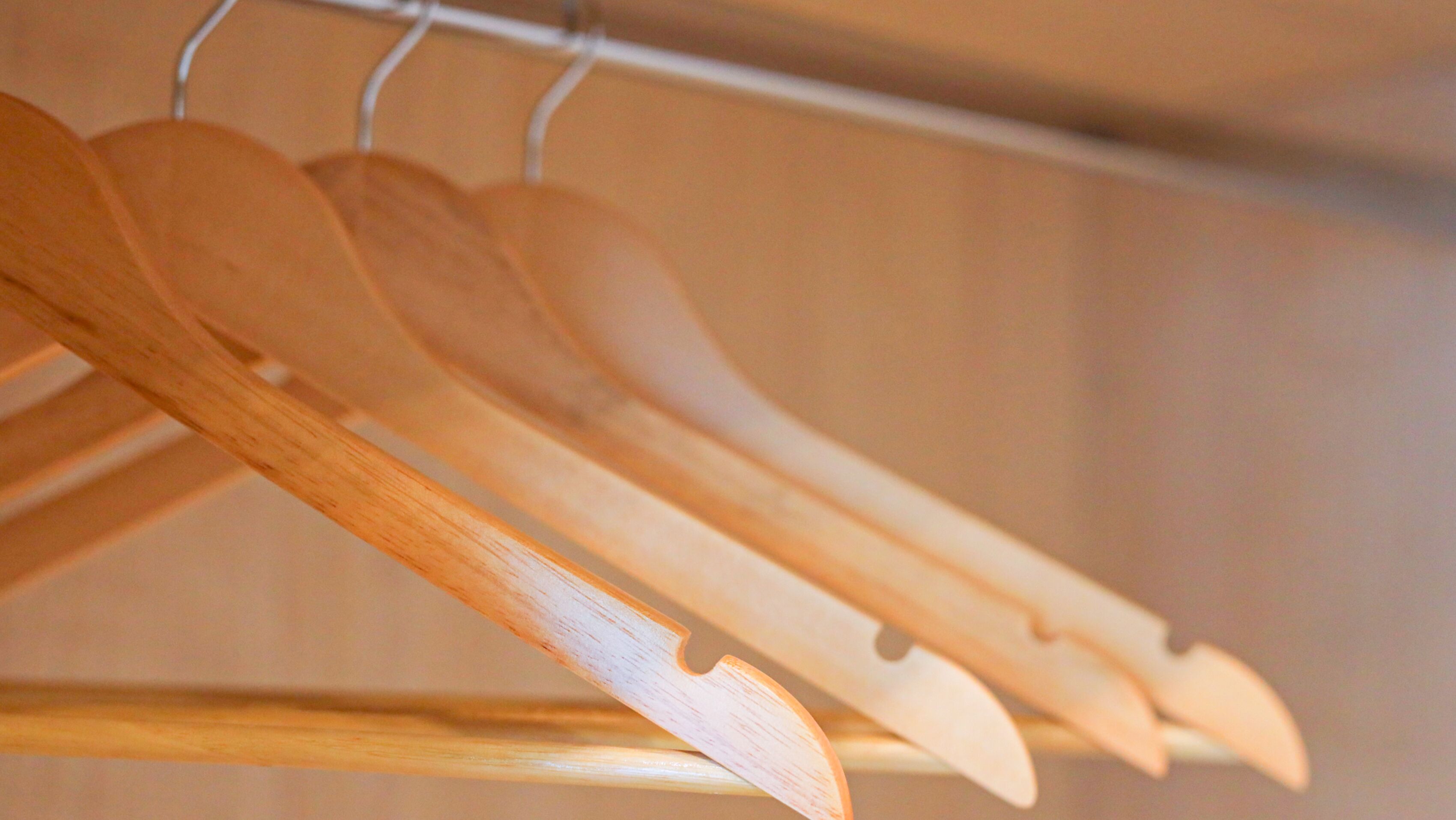 Wooden hangers on a metal rack.