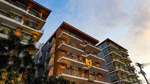 A multi-story hotel with balconies, a prominent 'B2' sign, and surrounding palm trees. - B2 Suan Luang Rama 9 Srinakarin 42 Boutique & Budget Hotel (Bangkok)