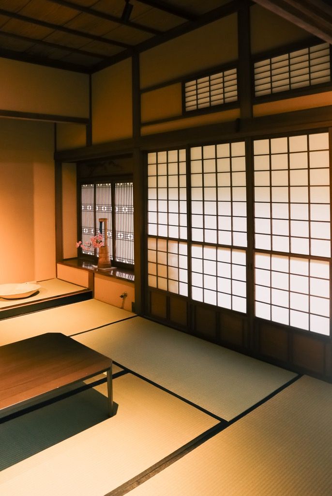 A traditional Japanese room with tatami flooring, shoji screens, and a low wooden table.