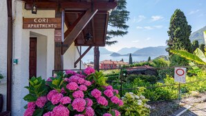 A building labeled 'CORI APARTMENTS' with a view of mountains and a lake. - Co.ri. Apartments (Menaggio)