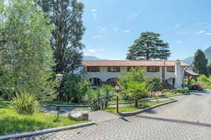 A building with a tiled roof, surrounded by greenery and trees. - Co.ri. Apartments (Menaggio)