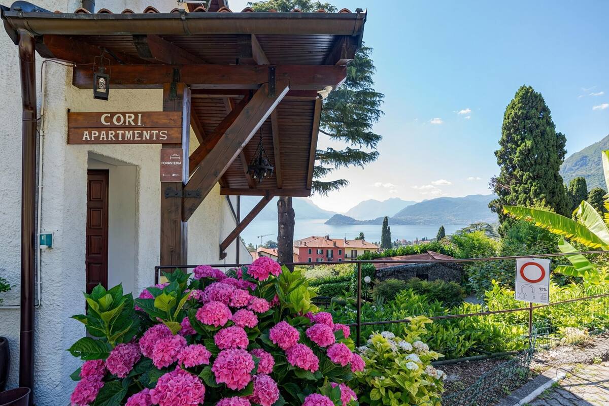 A building labeled 'CORI APARTMENTS' with a view of mountains and a lake.