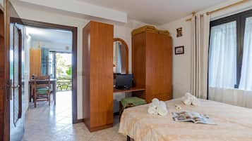 Une chambre d’hôtel avec un lit, une télévision, un bureau et une chaise.