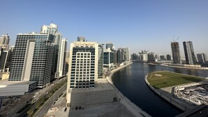 A cityscape with modern high-rise buildings, a river, and a bridge. - Manzil - Cozy Studio nr Downtown w Canal Views (Dubai)