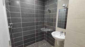 Een douche, handdoeken, zeep, toiletpapier