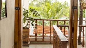 A room with a wooden-framed sliding door leading to a balcony with a tiled floor and a wooden railing. - Room-hb2 Triple Room With Shared Bathroo (Cartagena)
