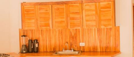 Una cocina con armarios de madera, un lavamanos y una encimera.