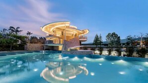Un hotel moderno con diseño circular, una piscina y vistas del paisaje circundante.