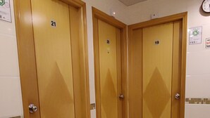 Un couloir avec trois portes en bois, numérotées 21, 20 et 19.
