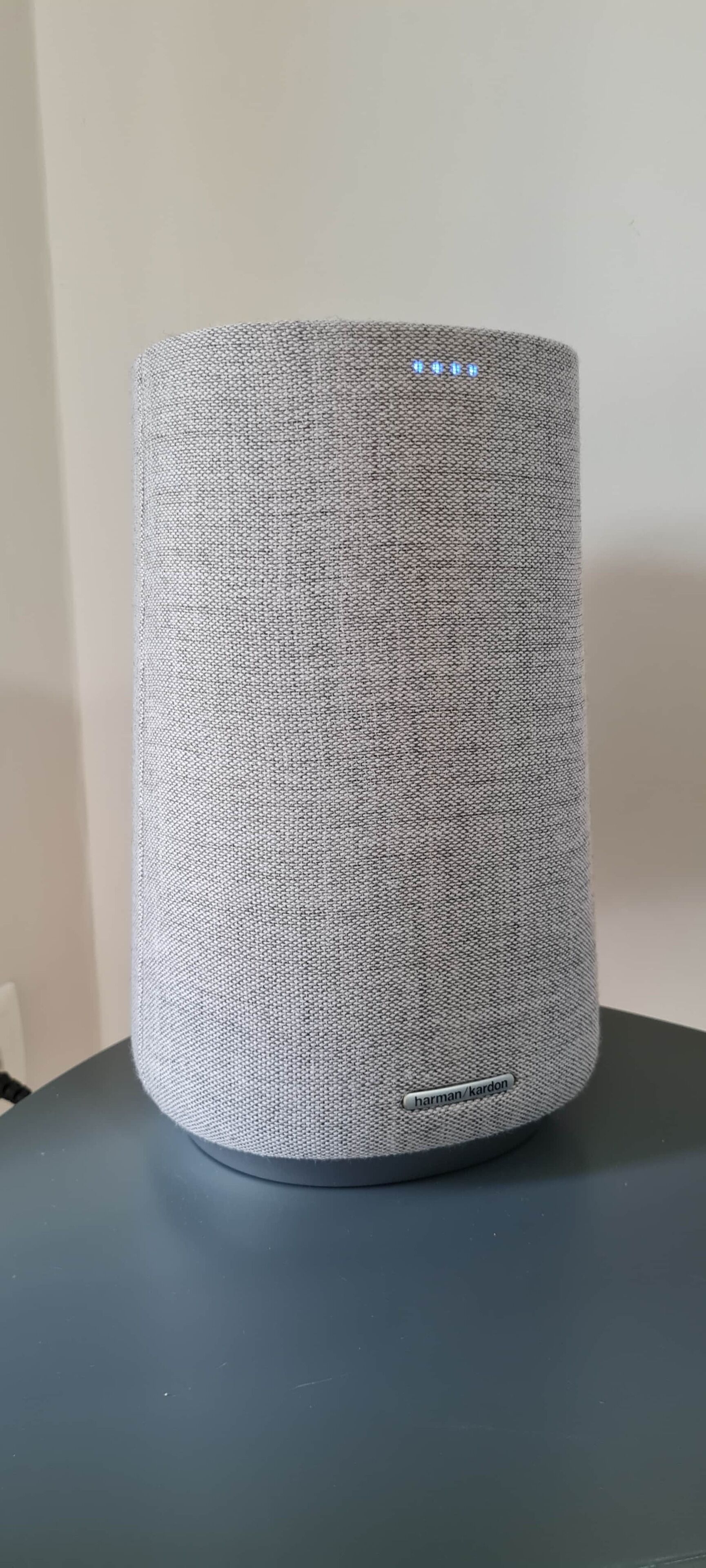 Un haut-parleur cylindrique à surface texturée, avec une étiquette sur sa base.