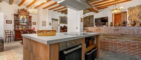 A kitchen with a central island, wooden cabinets, a built-in oven, and a brick backsplash.
