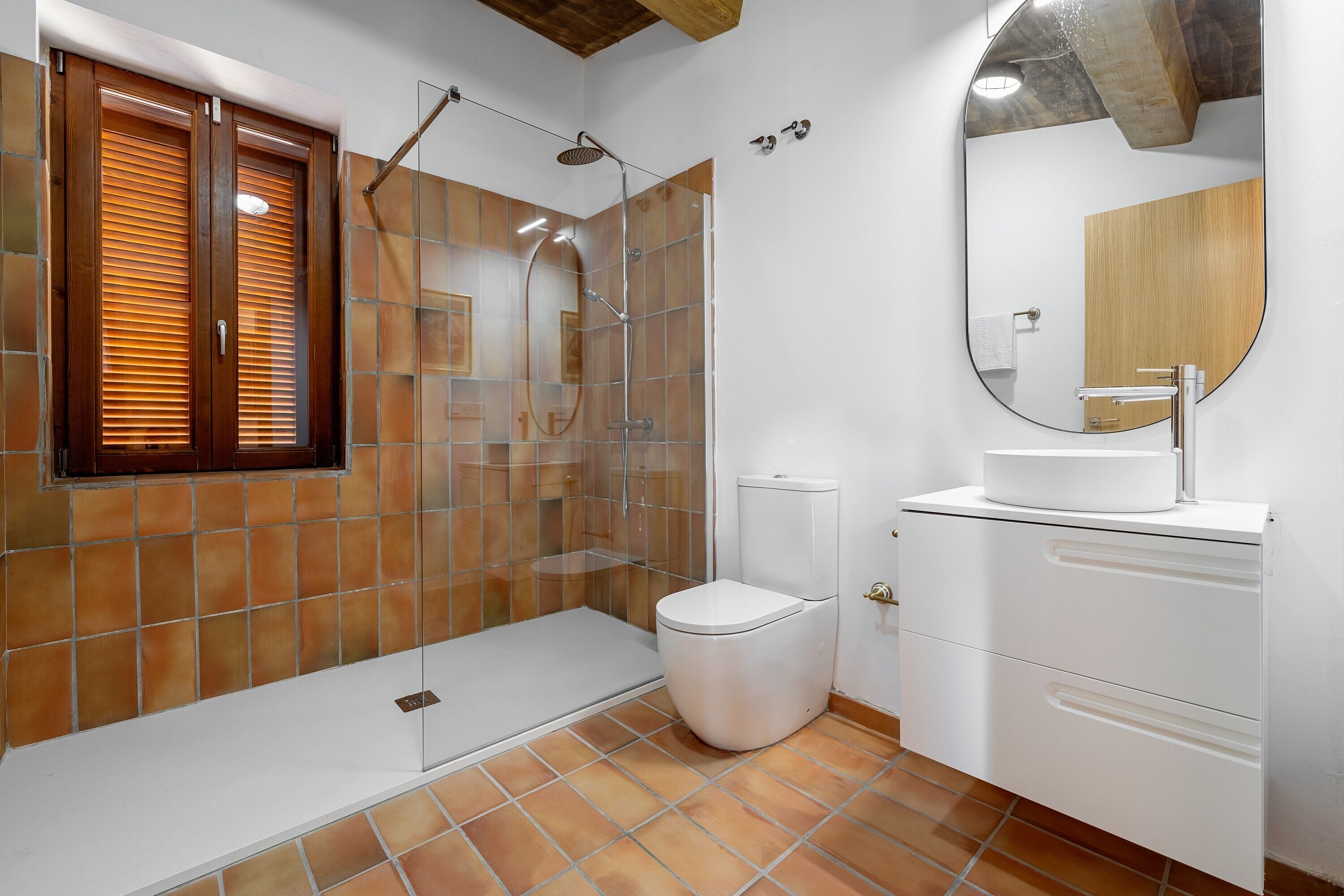 A bathroom with a shower, toilet, and sink.
