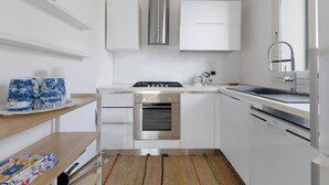 A modern kitchen with white cabinets, stainless steel appliances, and a built-in oven. - Apartment 'Venere In Villa' with Shared Pool, Wi-Fi and Air Conditioning (Marina di Ragusa)