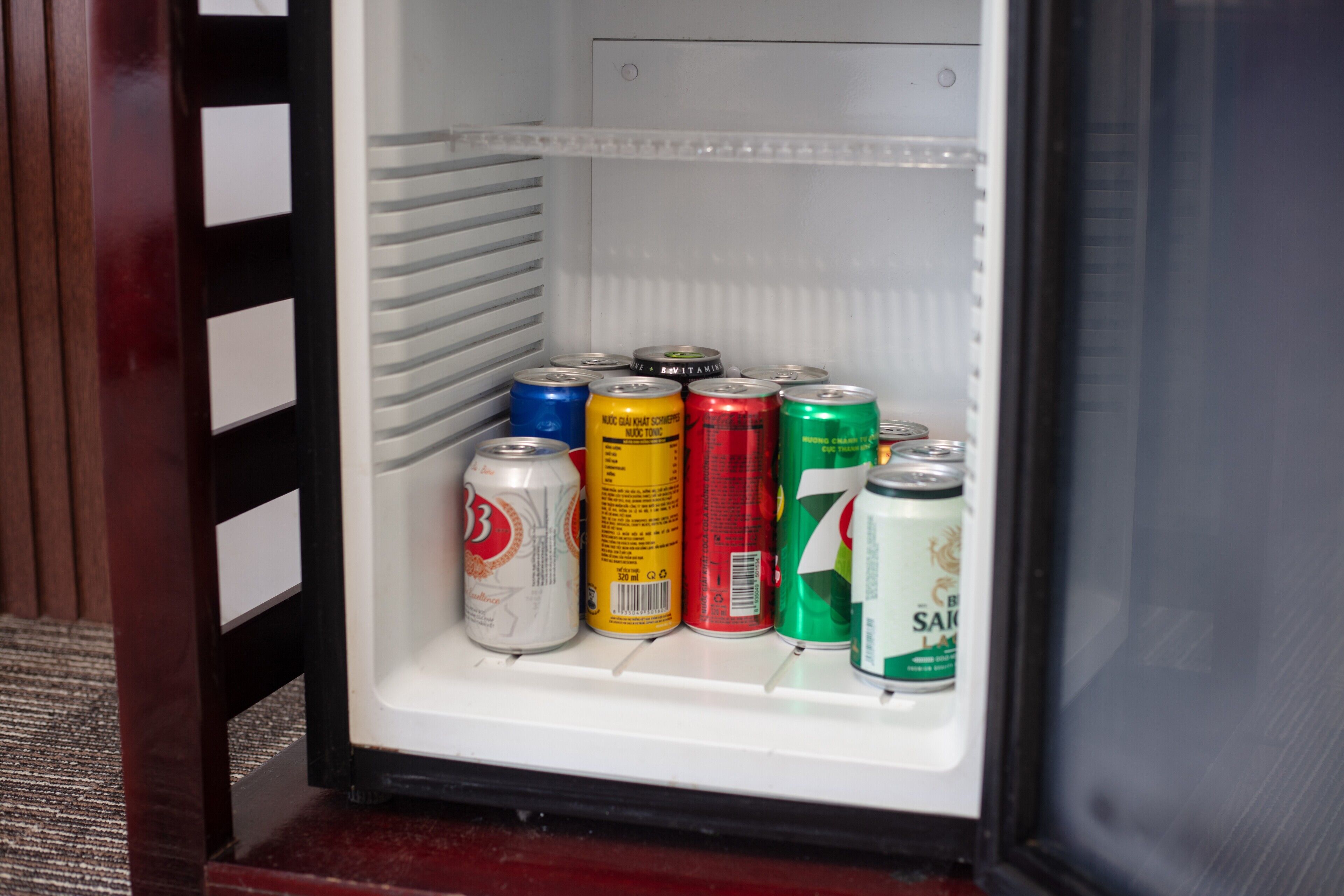 Un refrigerador con varias latas de bebidas.