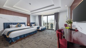 A hotel room with two beds, a desk, and a balcony.