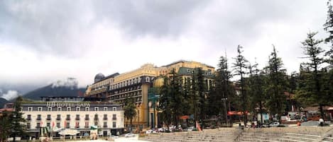 A hotel with a large outdoor amphitheater, a prominent building with a dome, and a mountainous backdrop.