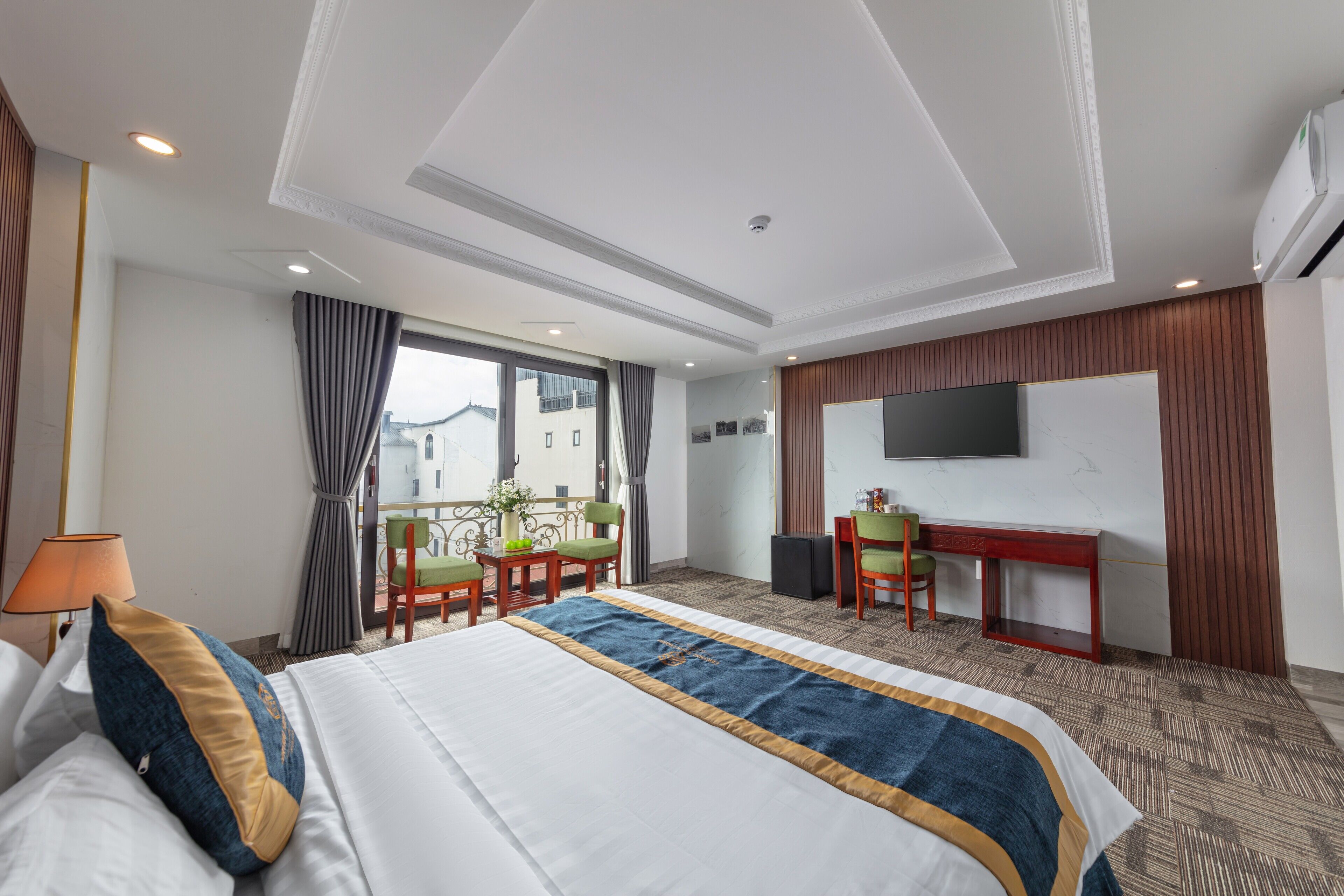 Une chambre d’hôtel avec un grand lit, un bureau, une télévision et une vue sur la ville.