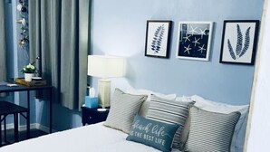 Une chambre bien rangée, avec un lit, des tables de chevet, un bureau et une chaise.