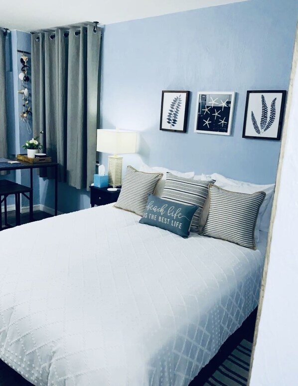 Una camera da letto ordinata con un letto, comodini, una scrivania e una sedia.