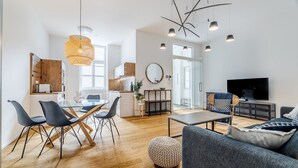 Ein modernes Wohnzimmer mit Sofa, Couchtisch und Essbereich mit Stühlen und Tisch.