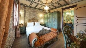 Ein Schlafzimmer mit einem großen Bett, einer Chaiselongue und einem grünen Schrank.