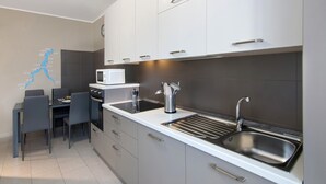 Una cucina moderna con forno a microonde, lavello e zona pranzo.